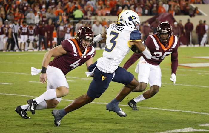 Sep 22, 2022; Blacksburg, Virginia, USA; West Virginia Mountaineers wide receiver Kaden Prather (3) runs the ball between Virginia Tech Hokies linebacker Dax Hollifield (4) and defensive back Chamarri Conner (25) at Lane Stadium.